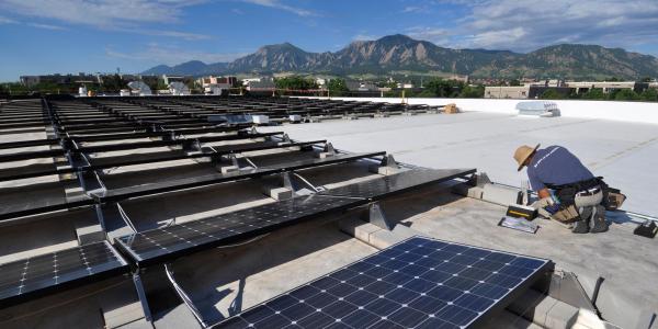 a technician installs solar panels on the roof of the building which houses the University of Colorado Center for Innovation and Creativity in Boulder. 